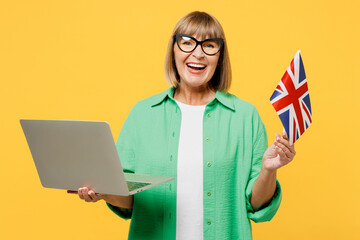 Elderly blonde IT woman 50s years old wear green shirt glasses casual clothes hold British flag use...