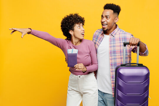 Traveler couple two friend family man woman wears casual clothes hold passport ticket bag isolated on plain yellow background. Tourist travel abroad in free time rest getaway. Air flight trip concept.