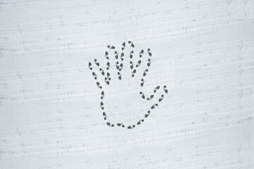 A hand symbol imprinted in snow with footprints.