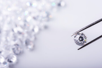 Diamonds of different cuts and sizes on light background with shadows.