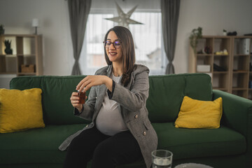 Obraz premium Expectant woman read leaflet take tablets medication or supplement