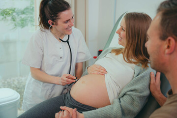 Happy pregnant woman visiting obstetrician doctor in maternity clinic - Female gynaecologist...