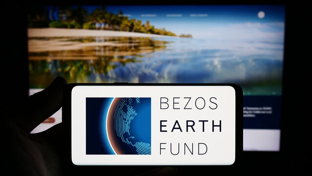 Stuttgart, Germany - 12-29-2023: Person holding smartphone with logo of environmental organization Bezos Earth Fund in front of website. Focus on phone display.