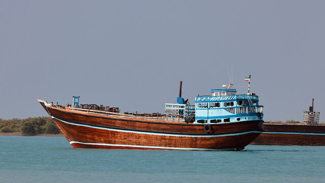 Traditional Dhow old wooden boat in the harbor of Iranian Qeshm Island. Tradition Lenj Fishing Boat in Qeshm Island in Southern Iran. Old wooden stealth smuggler's ship