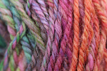 Closeup detail of colourful ball of wool, skeins of organic natural handspun and handdyed merino...