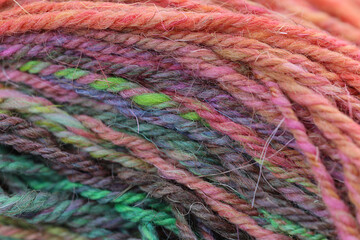 Closeup detail of colourful ball of wool, skeins of organic natural handspun and handdyed merino...