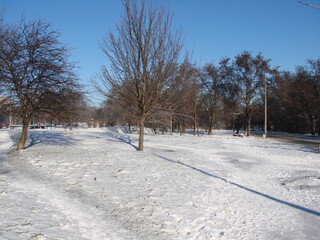 Panorama of a snowy playground under the rays of the morning sun on a clear frosty winter day.