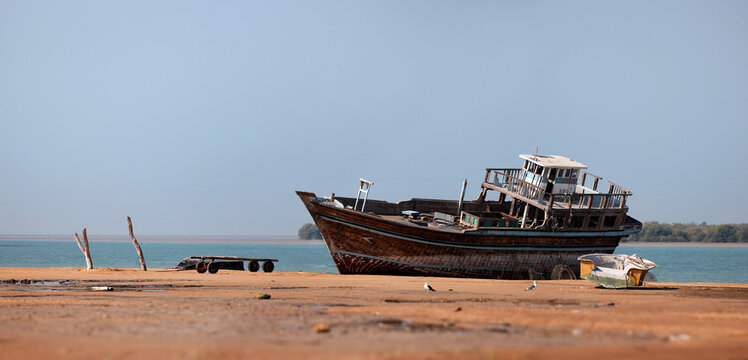 Traditional Dhow old wooden boat in the harbor of Iranian Qeshm Island. Tradition Lenj Fishing Boat in Qeshm Island in Southern Iran. Old wooden stealth smuggler's ship