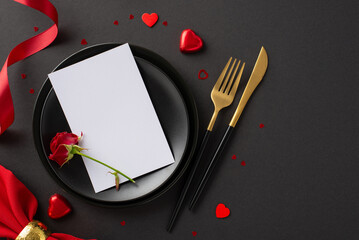 Sophisticated anniversary dinner: Elegant table top view featuring fine plates, menu card, cutlery, delectable chocolates, rose, luxurious silk ribbon on stylish black surface for customizable text