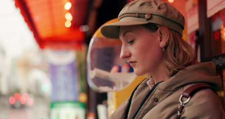 Woman, street and waiting for taxi with phone in rain, thinking or winter for travel, transport and cab in city. Girl, person and smartphone in metro for bus, driver and chauffeur on road in Tokyo - Powered by Adobe