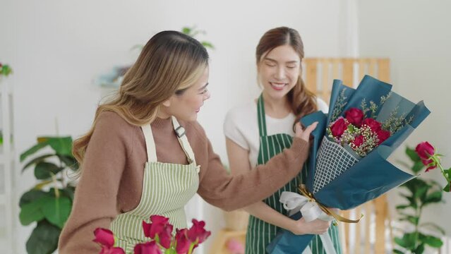 Two happy asian woman florist working together in flower shop. Young females florists arranging bunch in flower shop. Decorations and arrangements flowers bunch. Small business concept