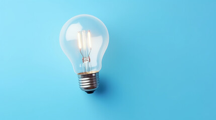 Incandescent light bulb on blue background with copy space, top view