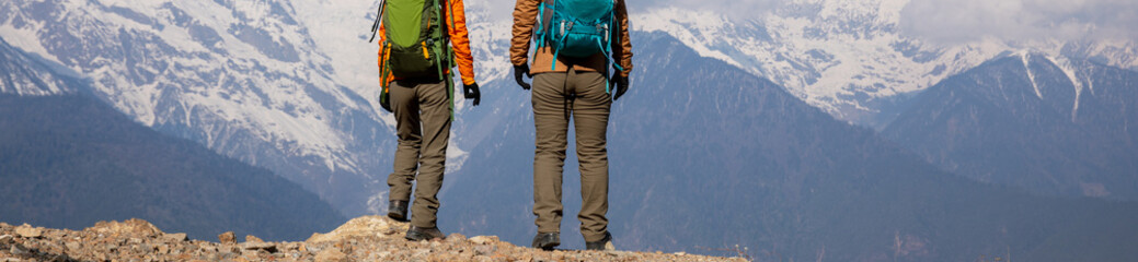 Two women backpackers hiking  in beautiful winter high altitude mountains