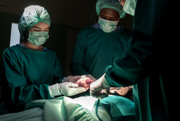 Serious surgeon team doing heart surgery in operation room