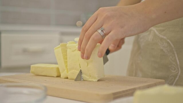 Woman Cutting The Butter On Wood Board In the Kitchen