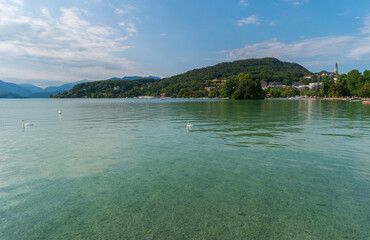 France, Annecy. Beautiful mountain landscape. View of Lake Annecy with white swans swimming in turquoise water.