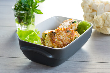 cooked vegetarian fried cauliflower cutlets in a ceramic form .