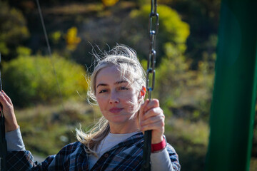 Girl swinging on a swing in the mountains