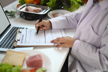 Cropped shot dietician working at desk with various healthy products. Healthy eating concept