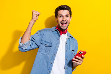 Photo portrait of handsome young guy raise fist hold telephone dressed stylish denim outfit...