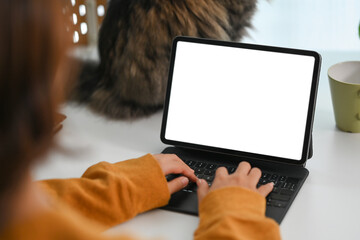 View over shoulder young female freelancer working on digital tablet at home