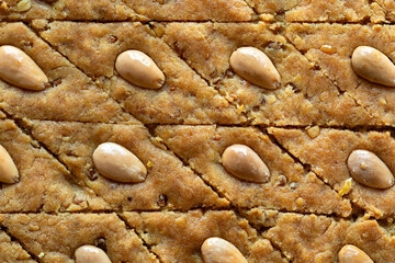 Close-up view of cake with almonds, fenugreek seeds and semolina. Palestinian helbeh cake. Dessert...