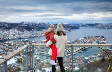 A mother and her daughter enjoying the winter view of the cityscape of Bergen, Norway, from a...