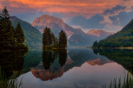 Golden Hour Serenity at Alpine Lake with Mirror Reflection, Majestic Mountains, and Vibrant Sunset Sky