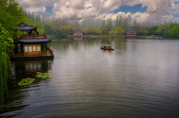 Fototapeta premium Traditional East Asian Pavilion Over Water, Boatman Rowing, Urban Skyline in Distance, Serene Nature Scene