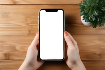 Vista superior de mano de mujer sosteniendo teléfono inteligente con pantalla vacía para introducir imágen y texto sobre fondo de mesa de madera.