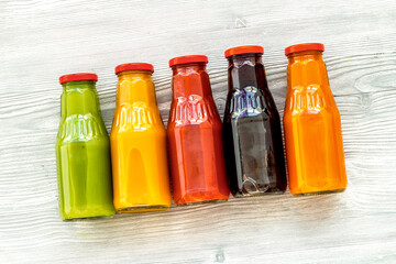 bottles with fresh carrot, tomato, apple, cucumber, lemon, pomegranate juices on white background top view copyspace