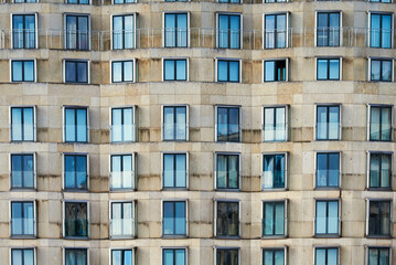 Fototapeta na wymiar Front view pattern of windows or casement on a modern building. Contemporary exterior with pattern of fenestra or fanlight conveys rental crisis in all major capitals or real estate market concept