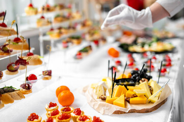 woman hands of a waiter prepare food for a buffet table in a restaurant