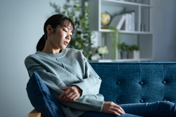 ソファで落ち込む女性
