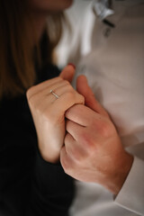 Engagement ring. Man in love putting a ring on woman finger. Propose. Closeup hands. Offer of hand and heart. Man making a marriage proposal to his woman. Engaged couple on Valentine's Day evening.