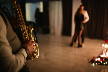Saxophonist's hands while playing jazz. Musician hold sax at romantic date on Valentine's Day in...