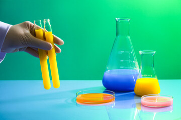 Concept laboratory tests and research with several erlenmeyer flasks and petri dishes of colorful...