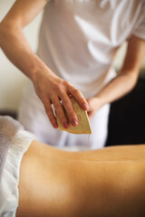 Crop masseuse using massage oil during skincare procedure