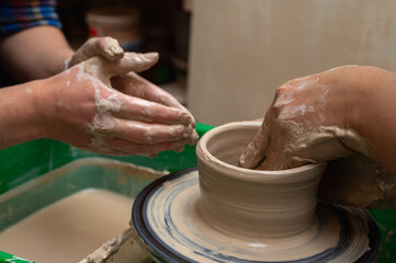 Clay, ceramics or hands in a design workshop working on an artistic cup or mug. The hand of a creative artist or worker making crafts in sculpture
