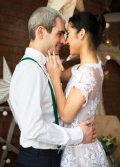 Couple near the brick wall decorated with the stars
