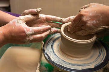 Clay, ceramics or hands in a design workshop working on an artistic cup or mug. The hand of a creative artist or worker making crafts in sculpture