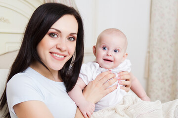 Happy smiling mother with six month old baby girl