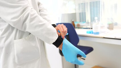 Close-up of a doctor using blue latex gloves in the laboratory of an hospital