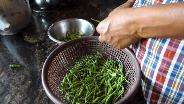 Culinary Craftsmanship: Traditional Uttarakhand Kitchen Scene - Man Processing Rat Tail Radish (Green Fali). Indian Cooking
