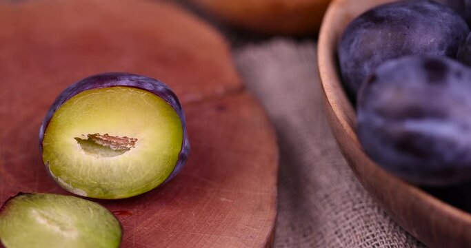 Wet purple plum on the table, delicious fresh harvest of oval-shaped and purple-colored plums in drops of water