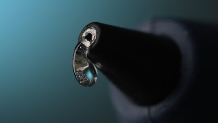 Glue gun Nozzle with Hot Liquid Glue. Close-up, shallow dof.