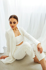Young woman with beautiful evening make up in white top, shirt and pants.