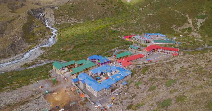 Aerial view of Tilicho base camp Nepal landscape, river, housings, green lands, adventurous tourism travel 4K