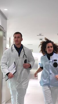 Medical colleagues walking and talking along the corridor of an hospital to the waiting room