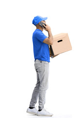 A male deliveryman, on a white background, in full height, with a box and a phone